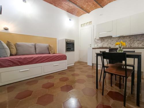 a room with a bed and a table and a kitchen at Civitas Vetula Guest House in Civitavecchia