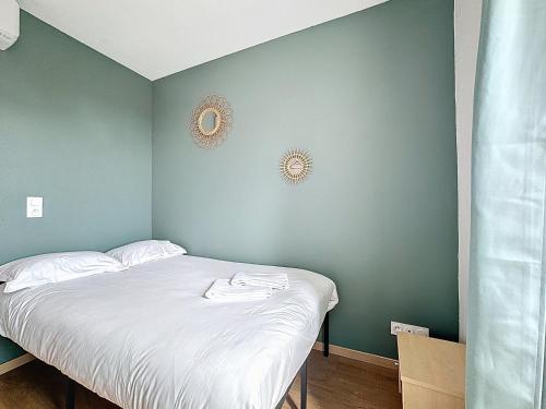 un lit dans une chambre avec un mur végétal dans l'établissement Mcosy 3, T3, 4 pers, clim, proche A75, à Coudes