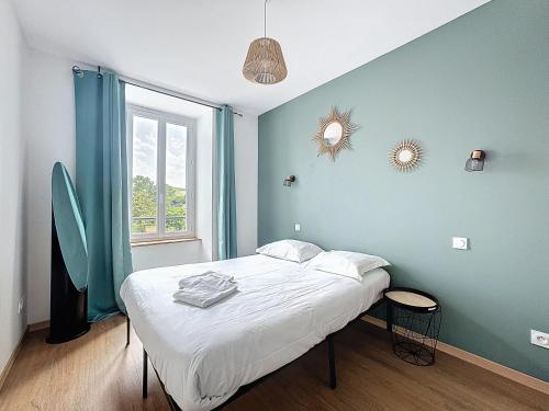 une chambre avec un lit avec un mur bleu dans l'établissement Mcosy 3, T3, 4 pers, clim, proche A75, à Coudes