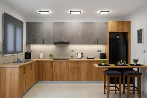 Una cocina con gabinetes de madera y un refrigerador negro. en Lavish Living Suite Heraklion Crete, en Kato Gouves