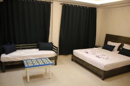 a room with two beds and a chair in it at Hôtel Medina in Sousse