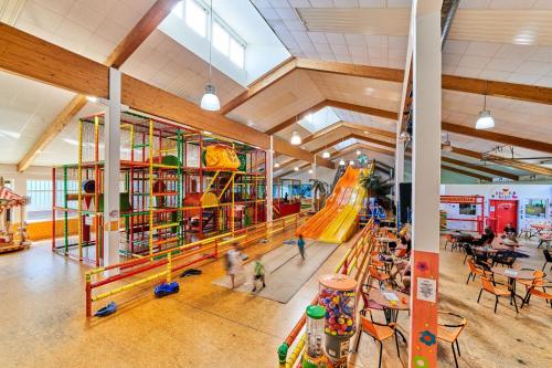 an indoor playground with a slide and children playing at Englmar Apartments with free WELLNESS and FITNESS in Sankt Englmar