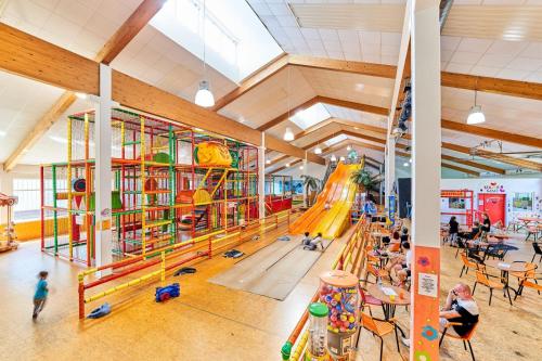 an indoor playground with a slide and people playing at Englmar Apartments with free WELLNESS and FITNESS in Sankt Englmar