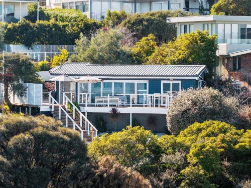a blue house on a hill with trees at The Peak of Mt Martha Spa and Sunset Views in Mount Martha