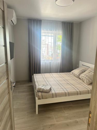 a bedroom with a bed and a window at Мини отель «Чайка» in Odesa