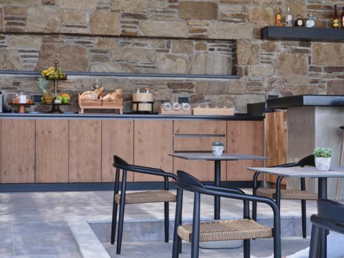 a restaurant with two tables and chairs in front of a counter at Kalea Mykonos in Ornos