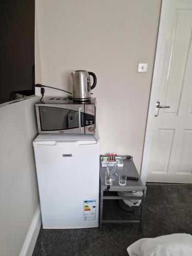 a small refrigerator with a microwave on top of it at Fairladies Barn Guest House in St Bees