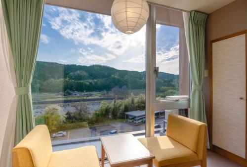 a living room with a large window with a view at 神通峡春日温泉ゆーとりあ越中 in Toyama