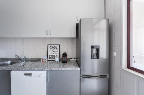 a kitchen with a stainless steel refrigerator and a sink at GuestReady - Comfortable Gaia Escape in Vila Nova de Gaia