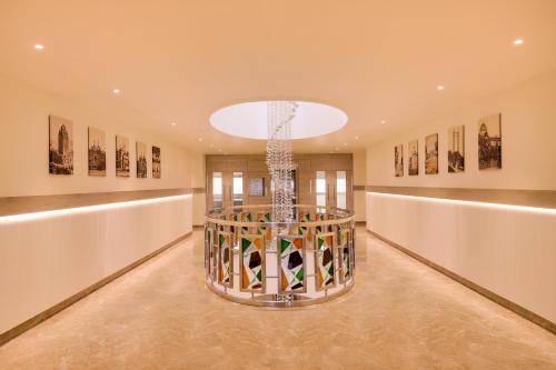 a large room with a chandelier and paintings at Lemon Tree Hotel, Jamnagar in Jamnagar