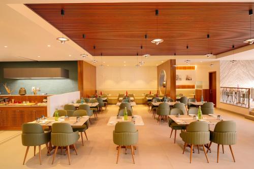 a large dining room with tables and chairs at Lemon Tree Hotel, Jamnagar in Jamnagar