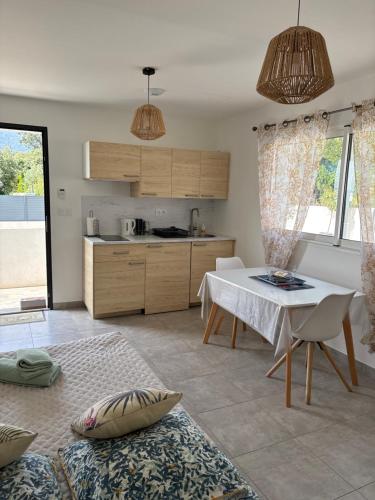 un salon avec une table et une cuisine dans l'établissement Les jardins de Saint Pancrace, à Corte