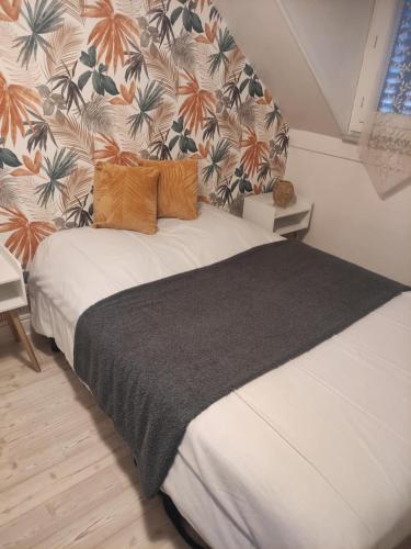 - une chambre avec un grand lit et une couverture noire dans l'établissement Villa Lumière, à La Bourboule