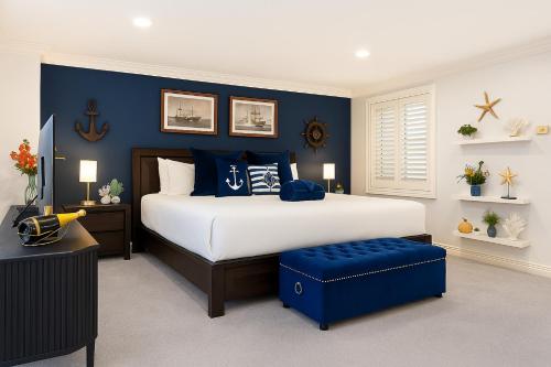 a bedroom with a large bed with blue walls at King Bed Harbour View - Captain's Retreat in Sydney