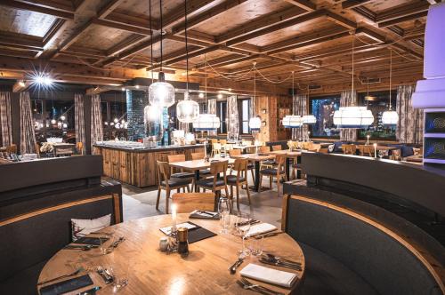 a restaurant with wooden tables and chairs and a bar at Sport & Wellness Hotel Das Falkenstein - Natural Swimming Lake - Matrix GYM - Summercard inklusive - Authentic experience - Flying wellness with Pool in Kaprun