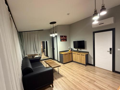 a living room with a black couch and a tv at Taksim alkan tower residence in Istanbul