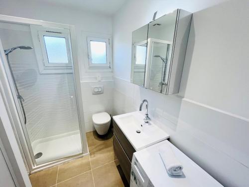 une salle de bain blanche avec une douche et un lavabo dans l'établissement Appartement T2 Mer Parking Conciergerie, à Bandol