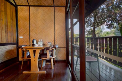 a table and chairs on a porch with a balcony at Lampang River Lodge in Lampang