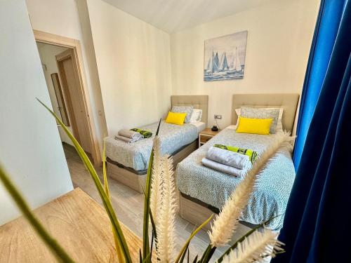 a room with two beds with yellow pillows at Casa Lily in Antigua