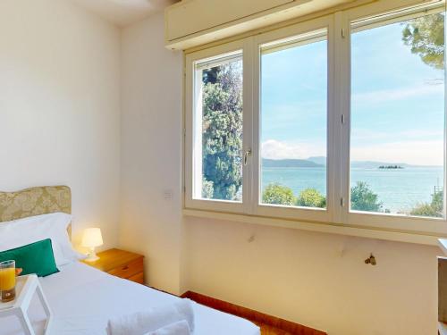 a bedroom with a bed and a large window at Villa 7 Bello by Bookinggardalake in Raffa