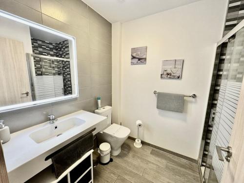 a white bathroom with a sink and a toilet at Casa Lily in Antigua