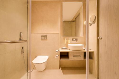 a bathroom with a toilet and a sink at Lemon Tree Hotel, Jamnagar in Jamnagar