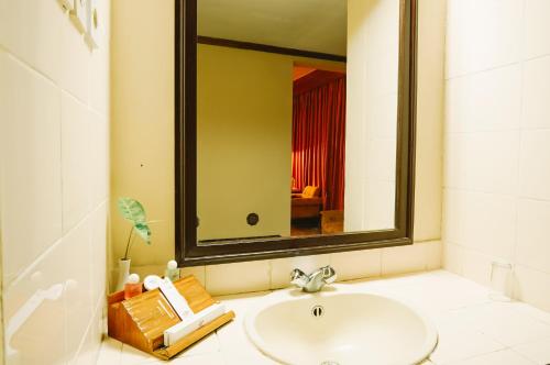 a bathroom with a sink and a large mirror at Hotel Sahid Toraja in Makale