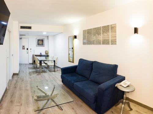 a living room with a blue couch and a table at Bellavista Sevilla in Seville
