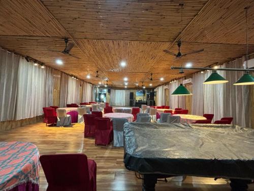 a banquet hall with tables and chairs and lights at Okho Resort Kalka Panchkula in Kālka