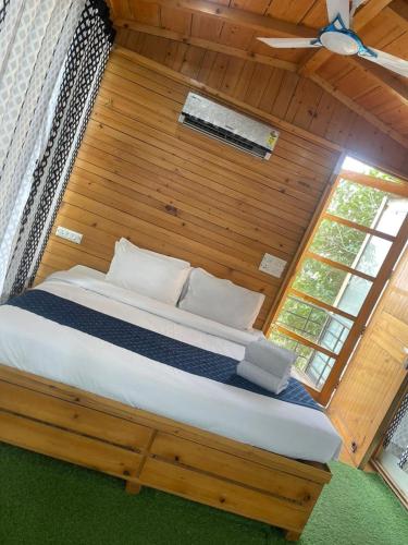 a large bed in a room with a wooden wall at Okho Resort Kalka Panchkula in Kālka