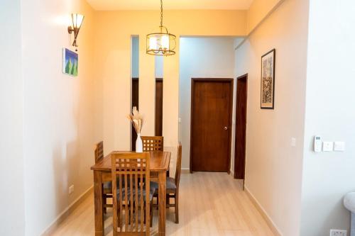 a dining room with a wooden table and chairs at The Greige 3 Lakeside Condo in Entebbe in Entebbe