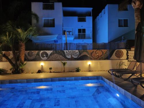 a swimming pool in front of a house at night at Villa Elia Blue , hot tube , heated pool in Paralimni
