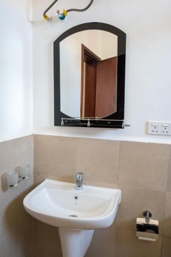 a bathroom with a sink and a mirror at The Greige 3 Lakeside Condo in Entebbe in Entebbe