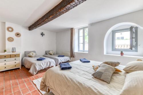 a bedroom with three beds and a window at Au Pied de la Cité - Terrasse - Climatisation - Wifi in Carcassonne