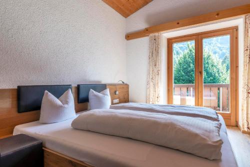 a bedroom with a large bed with a window at Landhaus Schneider in Schruns-Tschagguns