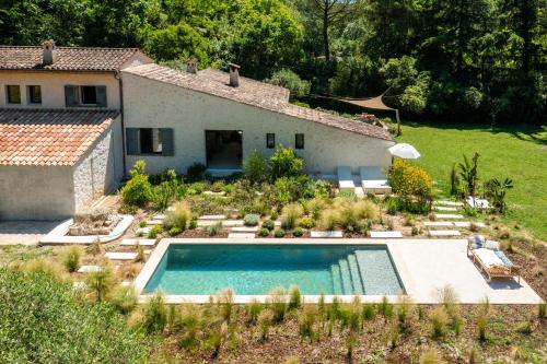 une maison avec une piscine en face d'une cour dans l'établissement Villa Health, à Tourrettes-sur-Loup