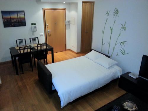 - une chambre avec un lit, une table et un bureau dans l'établissement Jardim das Madalenas, à Funchal