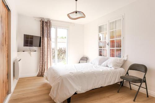 une chambre blanche avec un lit et une fenêtre dans l'établissement Maison Familiale à Grand Village, à Grand-Village-Plage