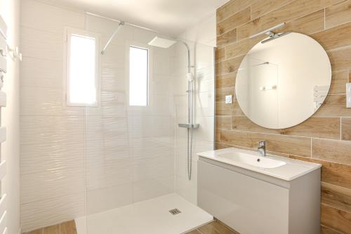 une salle de bain avec une douche, un lavabo et un miroir dans l'établissement Maison Familiale à Grand Village, à Grand-Village-Plage