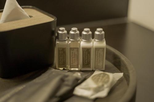 three glue bottles sitting on top of a table at Awann Sewu Boutique Hotel and Suite Semarang in Semarang
