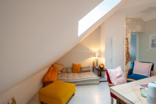 een woonkamer met een bank onder de trap bij L'Artiste - 60 m - 1 Bedroom in Orléans