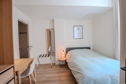 une chambre avec un lit, une table et un bureau dans l'établissement Le Bourg - 38m2 rénové - rue de Bourgogne, à Orléans