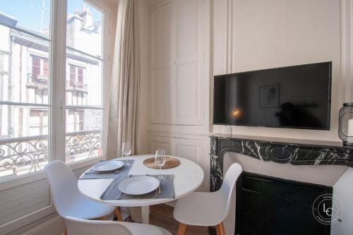 une salle à manger avec une table et des chaises et une télévision dans l'établissement Le Bourg - 38m2 rénové - rue de Bourgogne, à Orléans