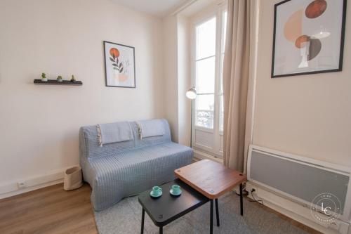 un salon avec une chaise bleue et une table dans l'établissement Le Bourg - 38m2 rénové - rue de Bourgogne, à Orléans