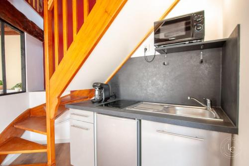 une cuisine avec un évier et un micro-ondes dans l'établissement La Maison d’Arc Romantic Spa Escape, à Saint-Péravy-la-Colombe