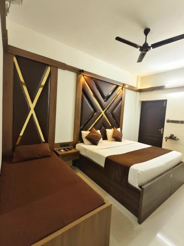 a bedroom with two beds and a ceiling fan at Hotel Shadow Regency in Ernakulam
