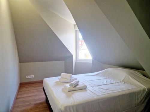 une chambre avec un lit avec deux serviettes dessus dans l'établissement L'Ermitage Cosy, à Cherbourg en Cotentin
