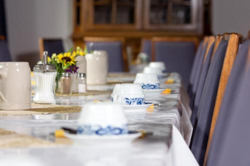 una mesa larga con platos azules y blancos. en Landhotel Westerwald, en Ehlscheid