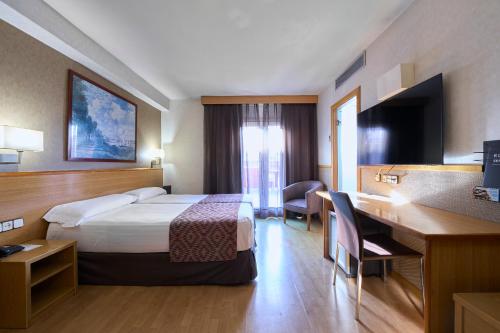 a hotel room with a bed and a desk at Catalonia Park Güell in Barcelona