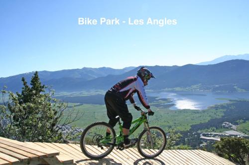 a man riding a bike on top of a mountain at Chalet Vue sous cet Angles in Les Angles